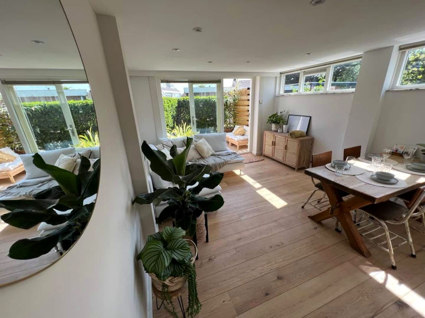 De woonkamer met veel planten en daglicht